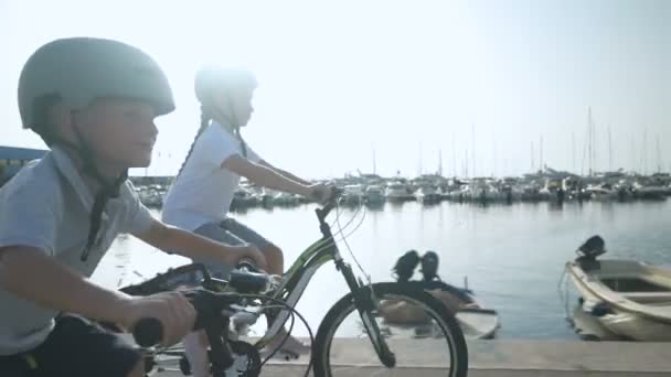 Brother and sister ride bicycles on a sunny day — Stock Video