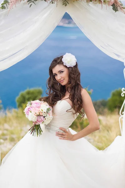 Jeune mariée dans une arche de mariage — Photo