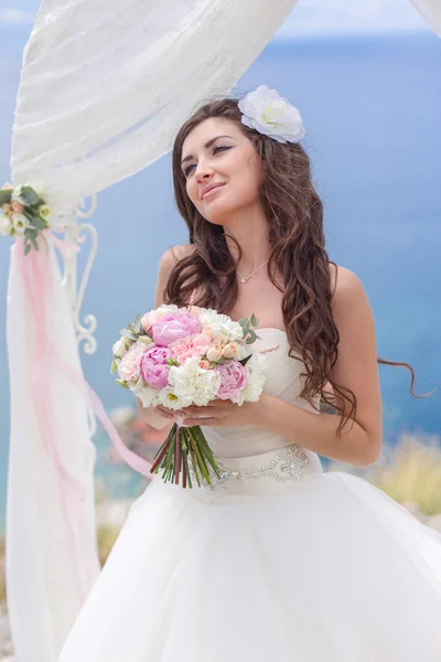 Jeune mariée dans une arche de mariage — Photo