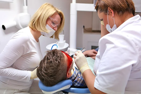 Doctor and nurse perform the procedure for dental treatment — Stock Photo, Image