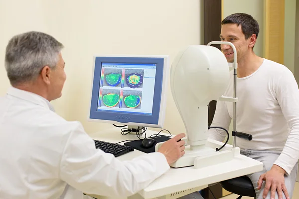 El hombre que tiene sus ojos examinados por un médico de edad avanzada ojo . — Foto de Stock