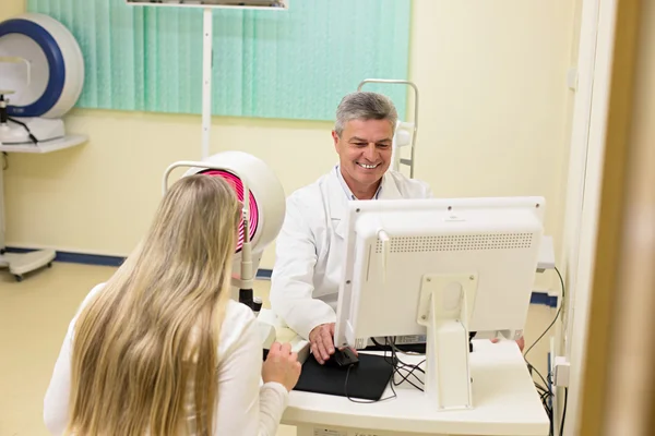 Jovem mulher ter seus olhos examinados por um olho bonito médico idoso . — Fotografia de Stock