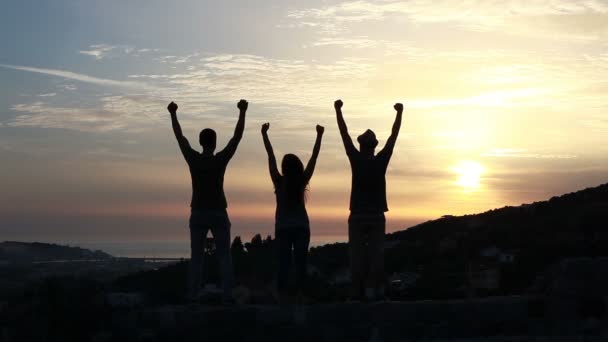 Amici guardando il tramonto mani in alto — Video Stock