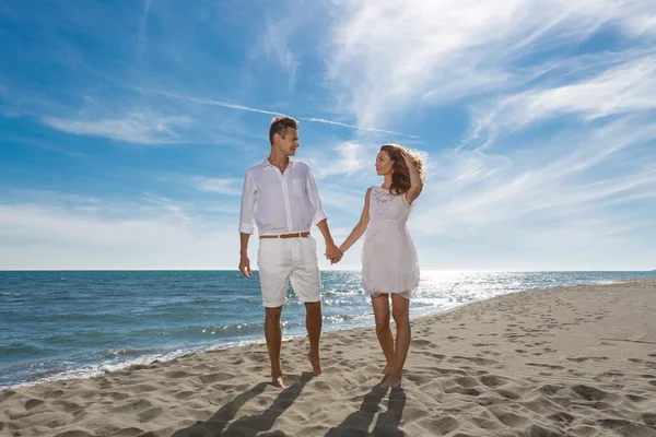 Happy couple in love walking on the beach — Stock Photo, Image