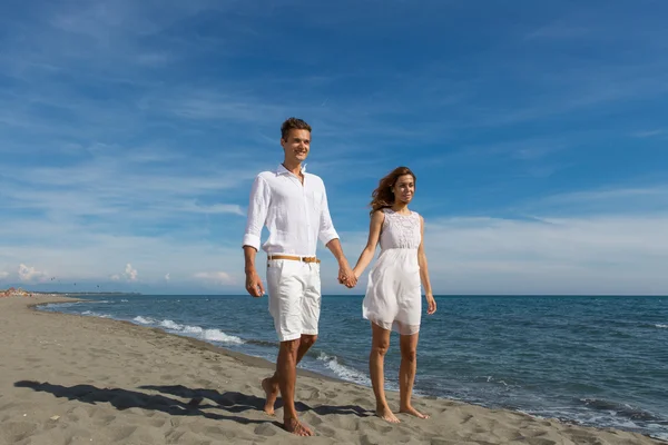 Happy couple in love walking on the beach — Stock Photo, Image