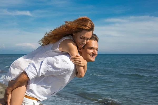 Gelukkige paar verliefd wandelen op het strand — Stockfoto