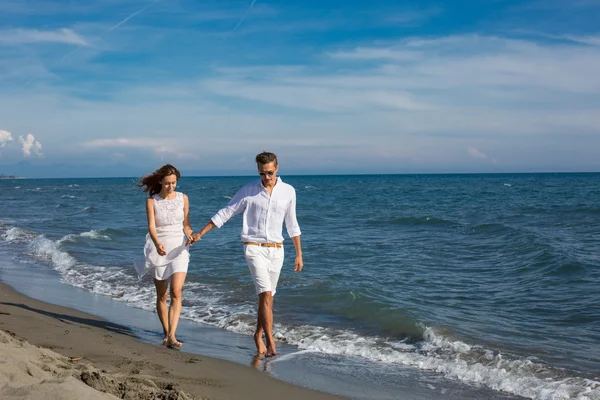 Happy couple in love walking on the beach — Stock Photo, Image