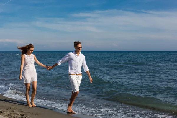 Happy couple in love walking on the beach — Stock Photo, Image