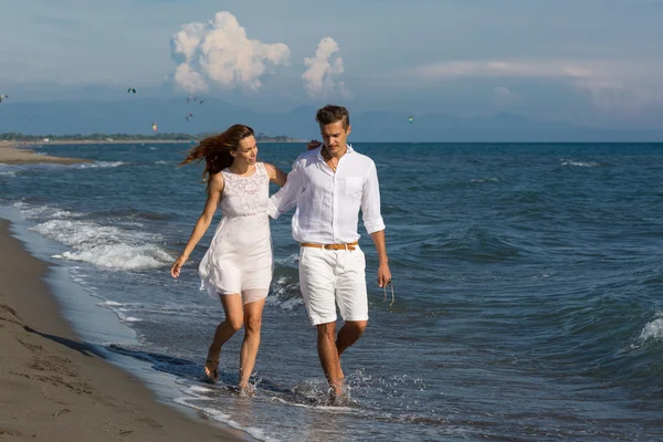 Happy couple in love walking on the beach — Stock Photo, Image