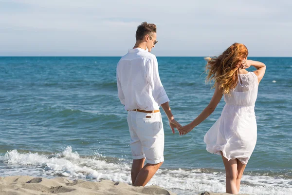 Couple heureux amoureux marchant sur la plage — Photo