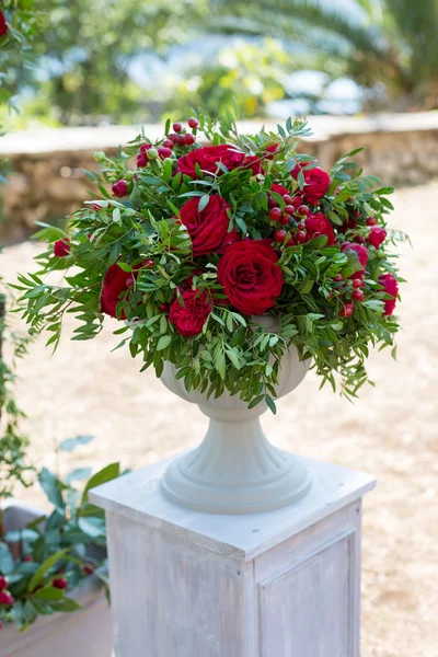 Bloemstuk in stenen kom met rode rozen — Stockfoto