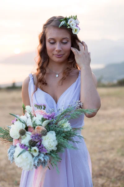 Noiva atraente está segurando um buquê de casamento — Fotografia de Stock