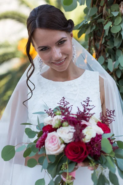 Hermosa novia al aire libre con un ramo — Foto de Stock