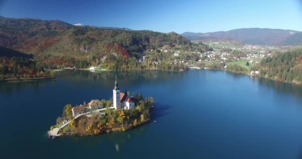 Vista aérea de la iglesia de San Martín en la isla y el paisaje del lago Bled con montaña — Vídeos de Stock