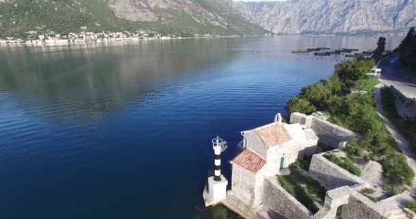 Luchtfoto van de vuurtoren en de kerk aan de ingang Boka Bay — Stockvideo