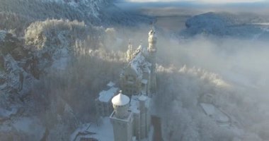 Neuschwanstein Şatosu havadan görünümü gündoğumu kış manzara içinde.