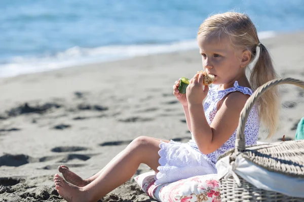 Petite fille profiter d'un pique-nique sur la plage — Photo
