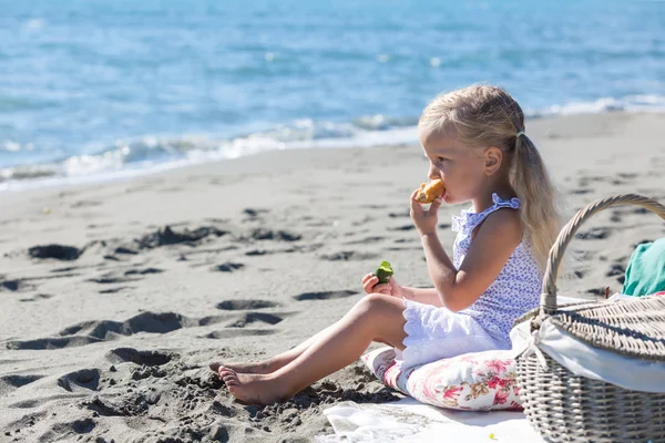 Meisje genieten van een picknick op het strand — Stockfoto