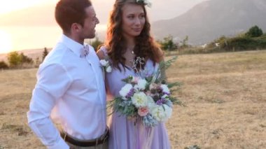 Gelin ve damat günbatımı üzerinde poz