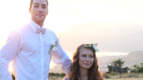 A menyasszony és a vőlegény pózol a naplemente — Stock videók