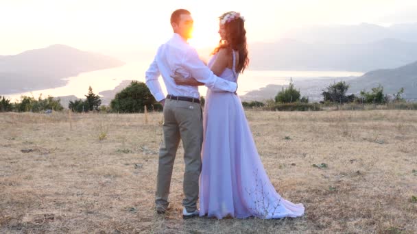 Das Brautpaar posiert im Sonnenuntergang — Stockvideo