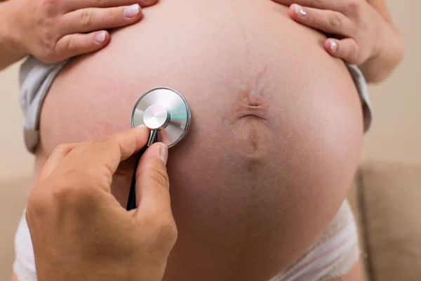 Stethoskop hört Schwangerschaftsbauch — Stockfoto