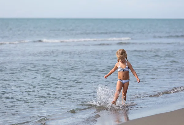 Meisje loopt langs het strand — Stockfoto