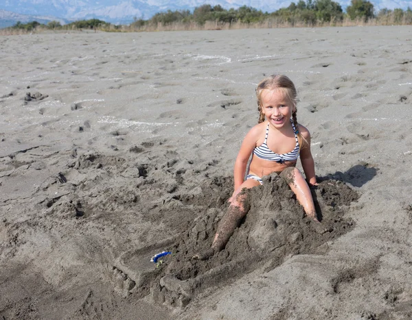 Девушка сломала свой песчаный замок — стоковое фото
