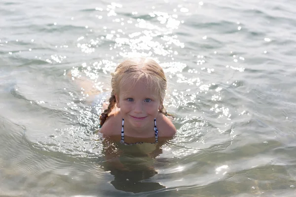 Ευτυχισμένος κορίτσι που κάθεται στη θάλασσα — Φωτογραφία Αρχείου