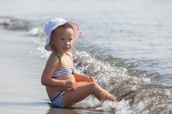 Fille est assise au bord de l'eau — Photo