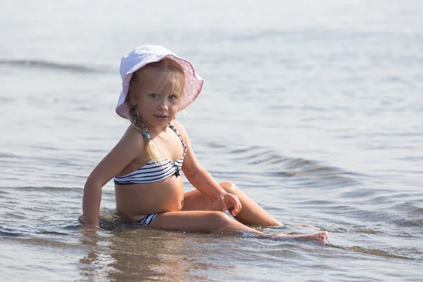 Fille est assise au bord de l'eau — Photo