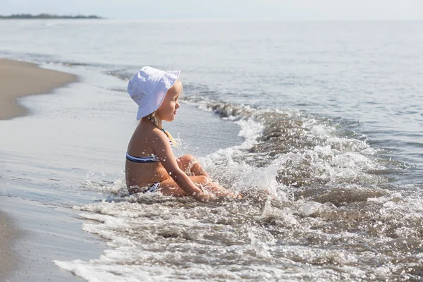 Chica se sienta en el borde de las aguas —  Fotos de Stock