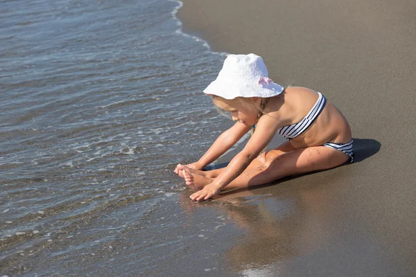 Chica se sienta en el borde de las aguas —  Fotos de Stock