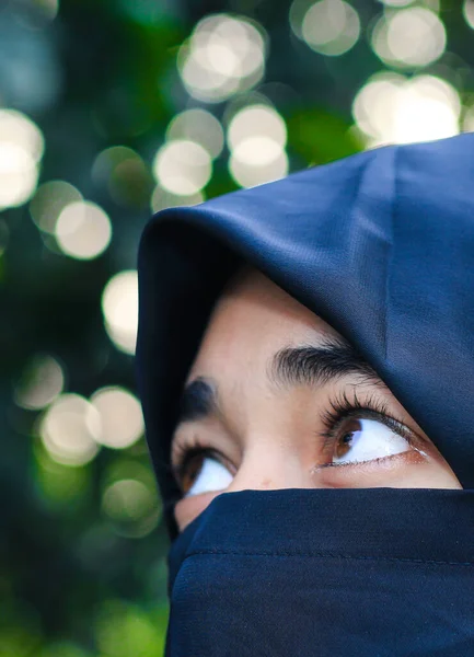 被头巾盖住的漂亮女人的脸 一个穆斯林女孩的完美闪亮的眼睛 具有背景的年轻的Niqab女孩肖像 — 图库照片