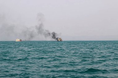 Bengal Körfezi 'nin feribot dumanı bacasından geliyor. Ana motor ateşlemesinden sonra demirli bir tankerin bacasından siyah egzoz dumanı geliyor. Açık denizde yelken açan gemiden siyah duman..