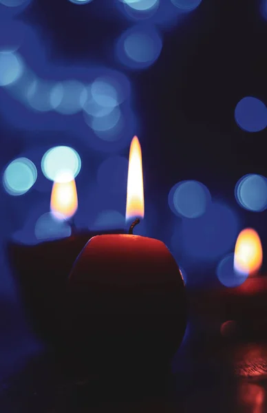 Candle lights in darkness with colorful light effects and bokeh for solemn moments and wallpaper. Candle flame light at night with the background.