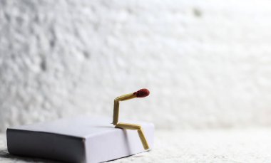 Zayıflık, üzüntü ve yalnızlık kavramı. İnsan yapımı kibrit çöpü. Kibrit çöplü adam partnersiz oturuyor. Kibrit kutusu sanat fotoğrafçılığı.