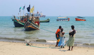 Balıkçılar ve renkli balıkçı tekneleri. Bangladeş 'teki balıkçılık endüstrisi. St. Martin Adası 'nda geleneksel Bangladeş balıkçı teknesi. Balıkçı, tekneyi okyanusa açılmaya hazırlıyor..