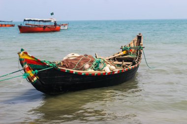 St. Martin Adası 'nda geleneksel Bangladeş balıkçı teknesi. Balıkçı, tekneyi okyanusa açılmaya hazırlıyor. Renkli balıkçı tekneleri.