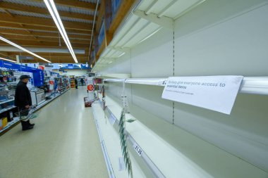 COVID-19 panik satın alımının sebep olduğu İngiltere 'deki bir süpermarkette boş raflar.