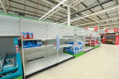 COVID-19 panik satın alımının sebep olduğu İngiltere 'deki bir süpermarkette boş raflar.