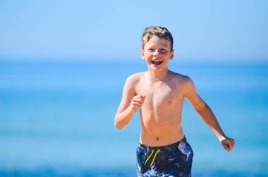 Mutlu genç çocuk sahilde iyi vakit geçiriyor.
