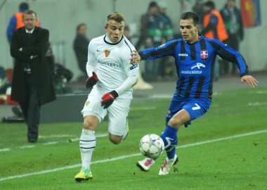 BUCHAREST, ROMANIA - NOVEMBER 22, 2011: Basel 'den Xherdan Shaqiri (L) ve Otel' den Laurentiu Iorga (R) Otelul Galati ile Ulusal Arena 'daki C Grubu arasında oynanan 2011 / 12 UEFA Şampiyonlar Ligi C Grubu maçı sırasında resmedildi..