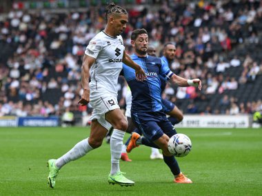 MILTON KEYNES, ENGLAND - SEPTEMBER 25, 2021: Dons (L) takımından Tennai Rosharne Watson ve Wycombe (R) takımından Joseph Mark Jacobson, MK Dons FC ve Wycombe Wanderers FC arasında oynanan 2021 / 22 SkyBet EFL League One maçında çekildiler. Anlaşıldı.