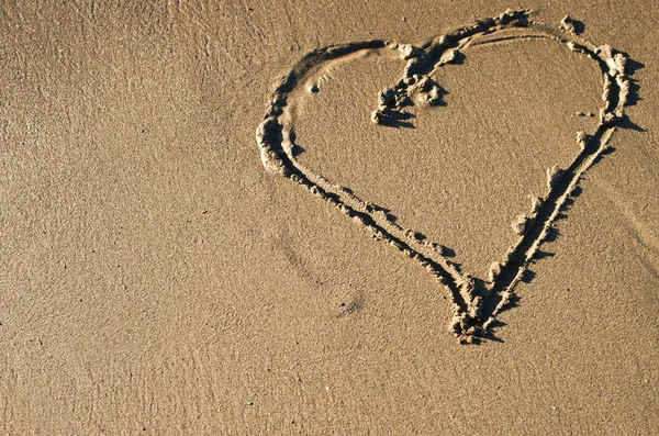 Сердце на пляже на закате — стоковое фото