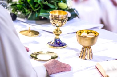 hand of the pope with consecrated host that becomes the body of jesus christ and chalice for wine, blood of christ, in the churches of rome and all over the world clipart