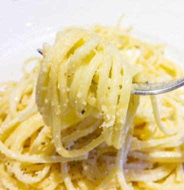 İtalya 'da öğle yemeği için spagetti, makarna, tereyağı, peynir, biber ve otlarla tatlandırılmış.