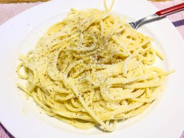 İtalya 'da öğle yemeği için spagetti, makarna, tereyağı, peynir, biber ve otlarla tatlandırılmış.