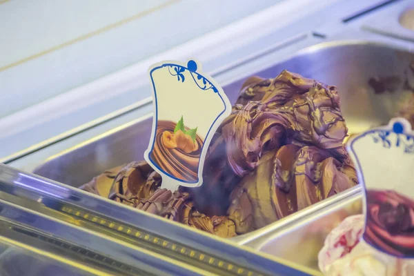 ディスプレイ チョコレート ピスタチオ クリーム ヘーゼルナッツ ミルク フルーツ 砂糖漬けの果物に多くのおいしい味のアイスクリーム店 ストック画像