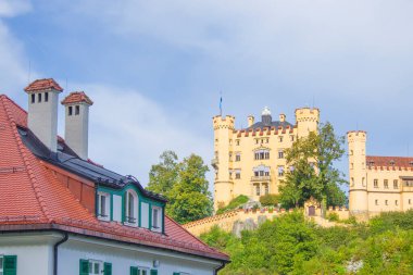Hohenschwangau, ünlü ortaçağ şatosu, ejderhalarla, şövalyelerle ve prenseslerle, mavi göllerin karanlık ormanlarının arka planına karşı.